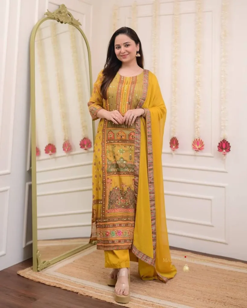 Woman wearing mustard yellow festive kurta set with ethnic embroidery and mirror work