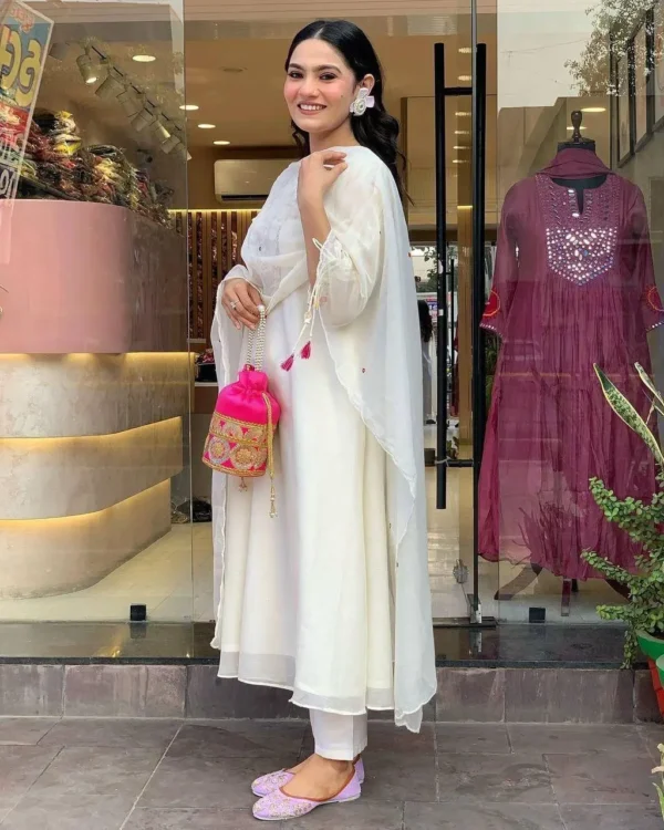 Woman wearing white kurta set with colorful embroidery and sheer dupatta – festive ethnic outfit