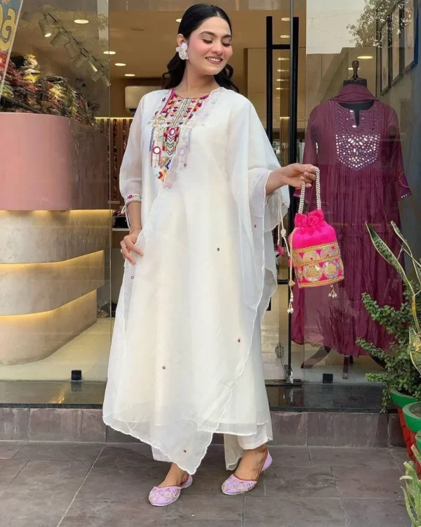 Woman wearing white kurta set with colorful embroidery and sheer dupatta – festive ethnic outfit