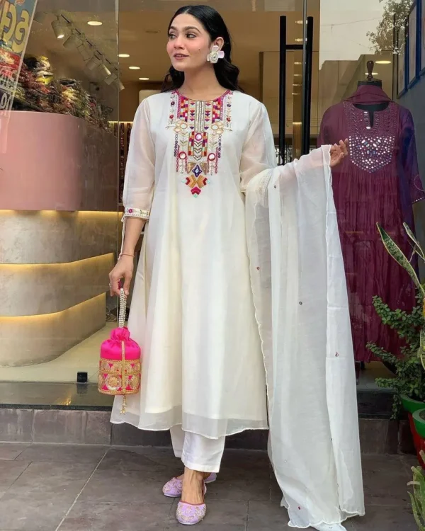 Woman wearing white kurta set with colorful embroidery and sheer dupatta – festive ethnic outfit