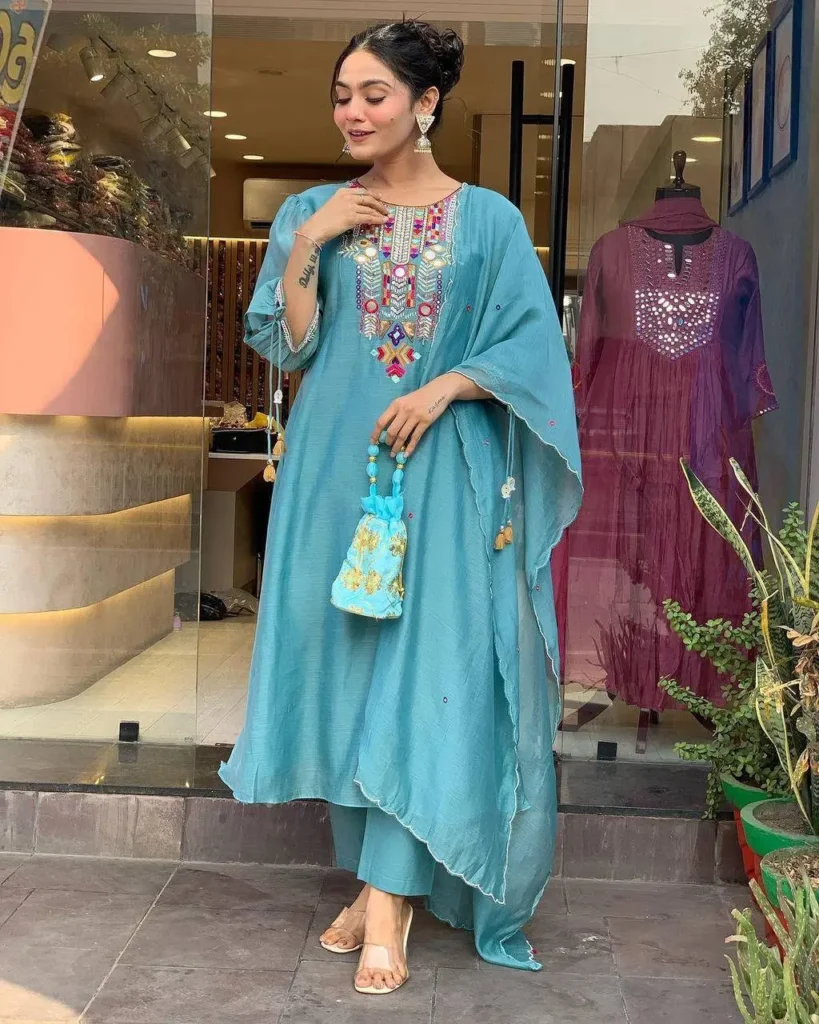 Woman wearing white kurta set with colorful embroidery and sheer dupatta – festive ethnic outfit