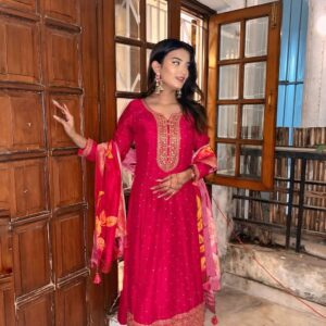 Woman wearing a dark pink embroidered kurta set with matching pants and festive dupatta