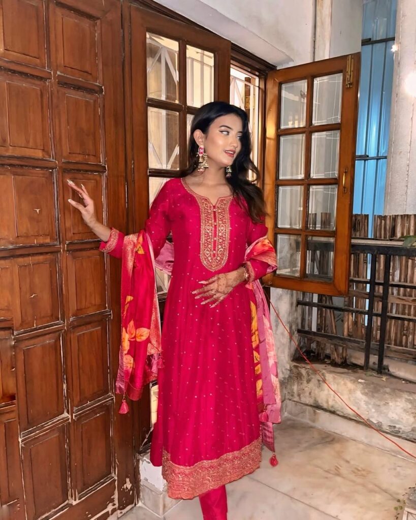 Woman wearing a dark pink embroidered kurta set with matching pants and festive dupatta