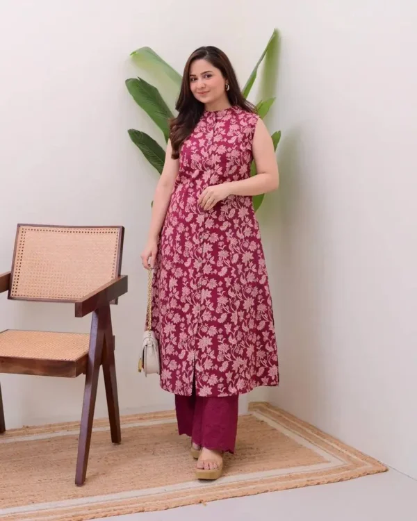 Model wearing a maroon sleeveless kurti set with white floral prints and matching palazzo
